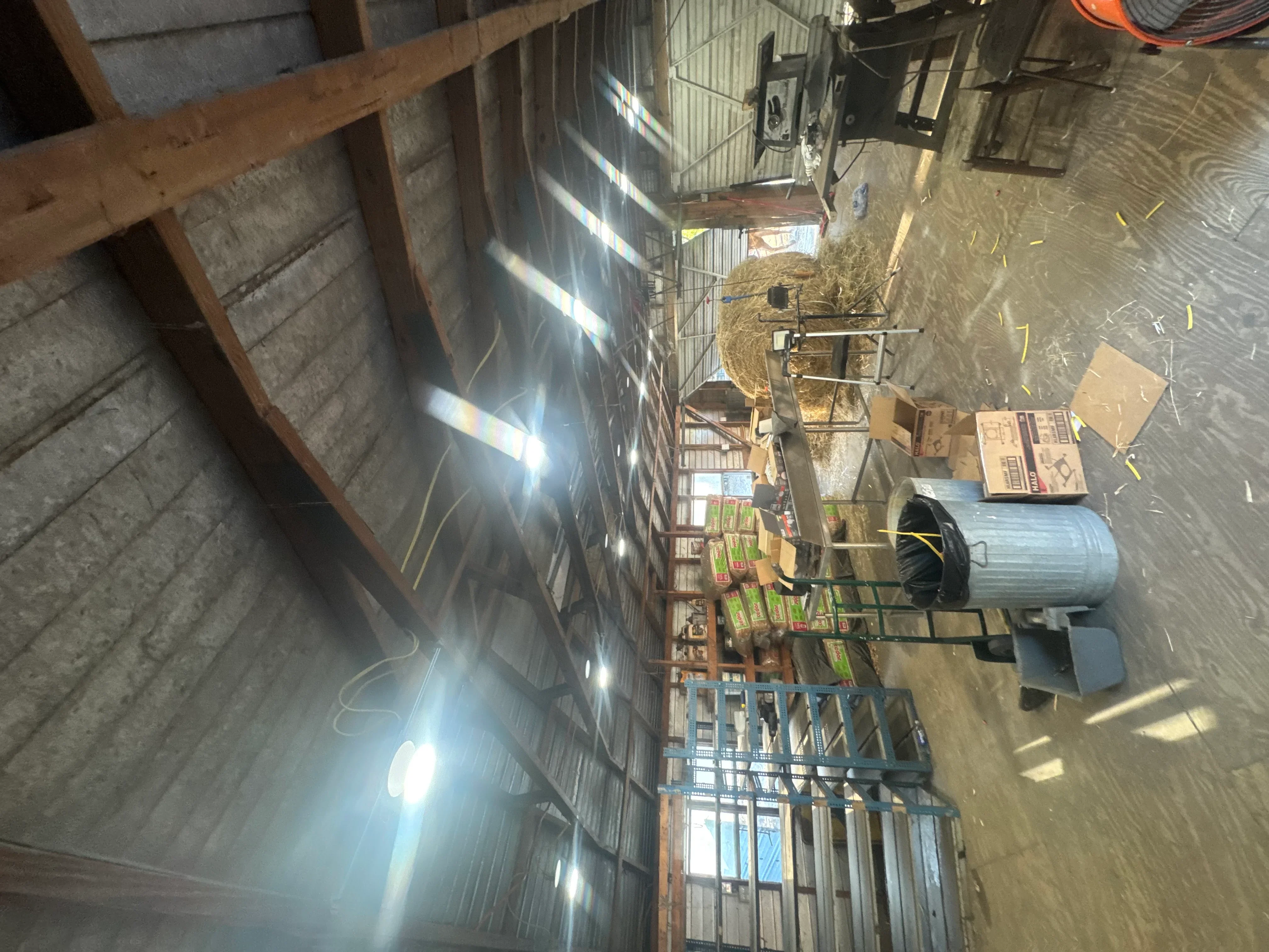 Industrial warehouse with LED lighting fixtures mounted on concrete block walls and timber beams