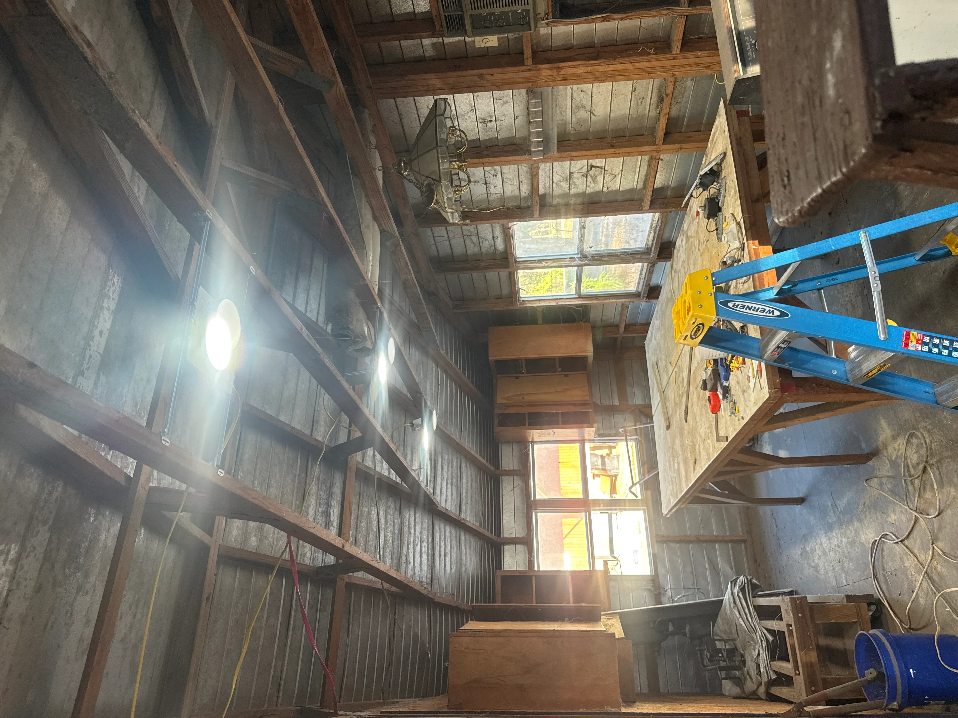 Industrial warehouse with LED high-bay lights mounted on steel beams and structural framework