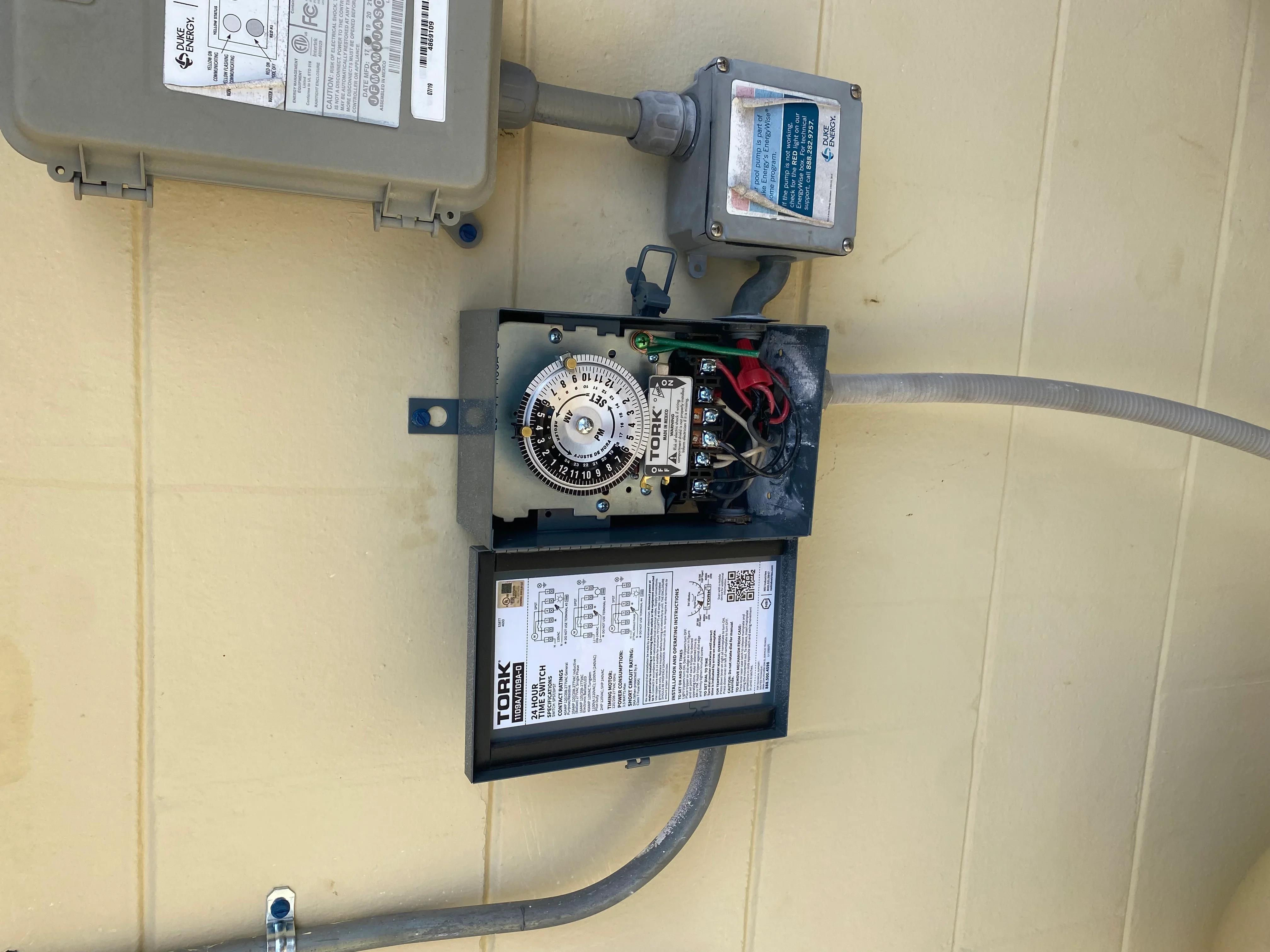 Tork pool timer control panel with contactor relay and conduit wiring on exterior wall